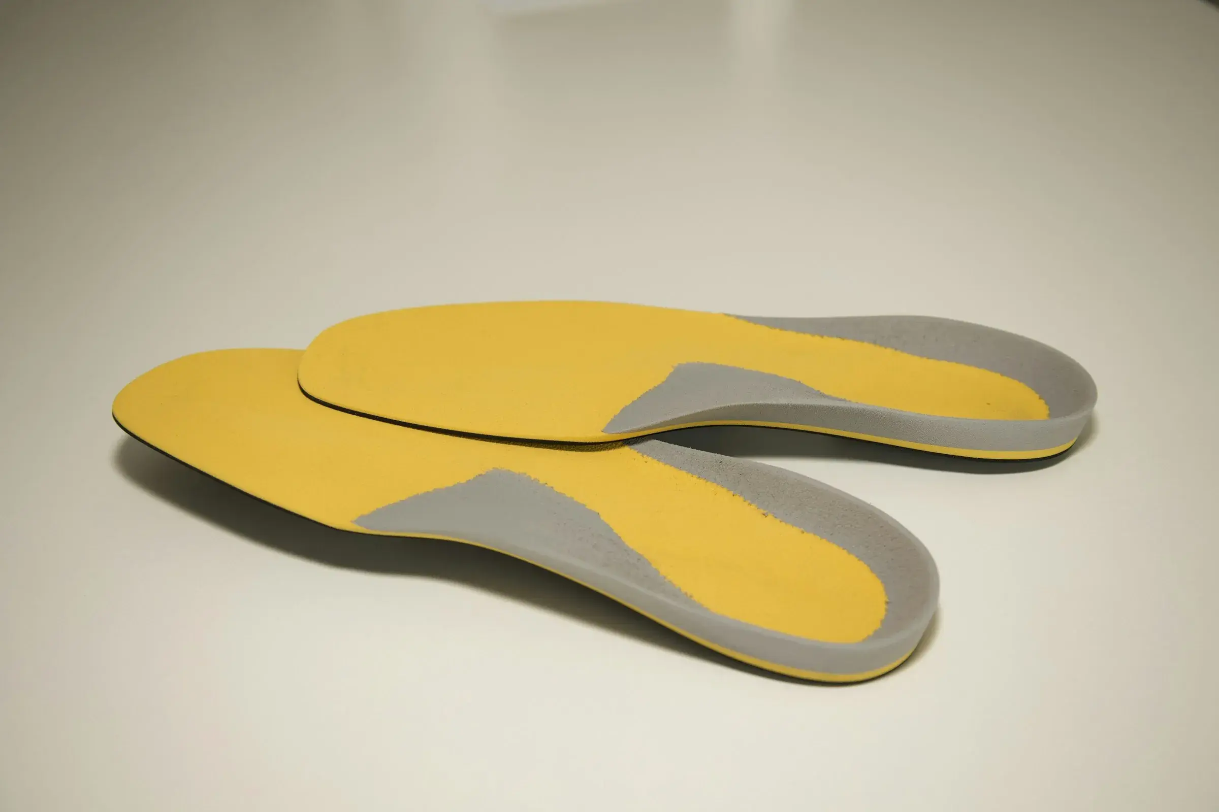 A pair of foot orthoses with contoured heel cups and arch support